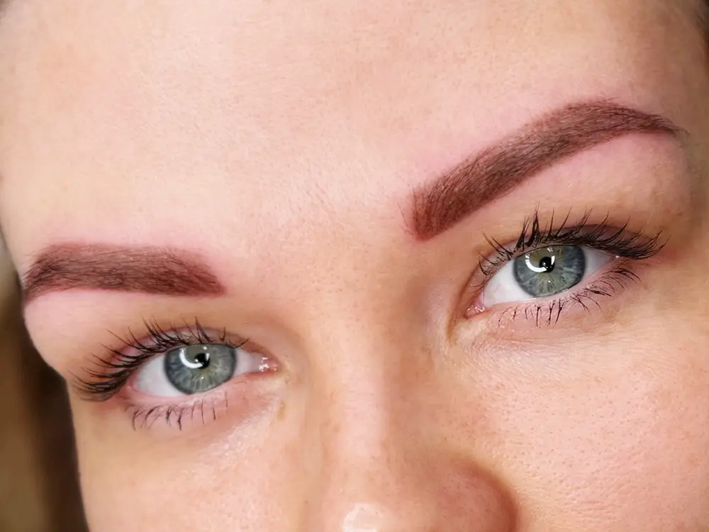 frissen tetovált szemöldök közelről, enyhén piros bőrrel a szemöldök tetoválás gyógyulási szakaszában